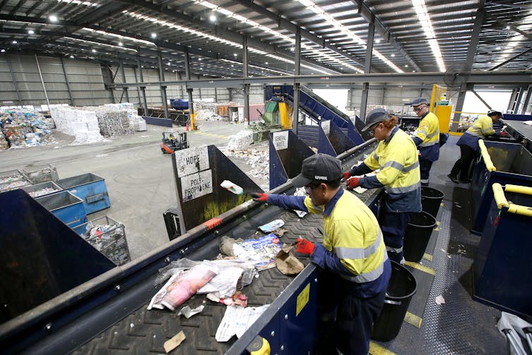Workers manually separate household recyclable waste