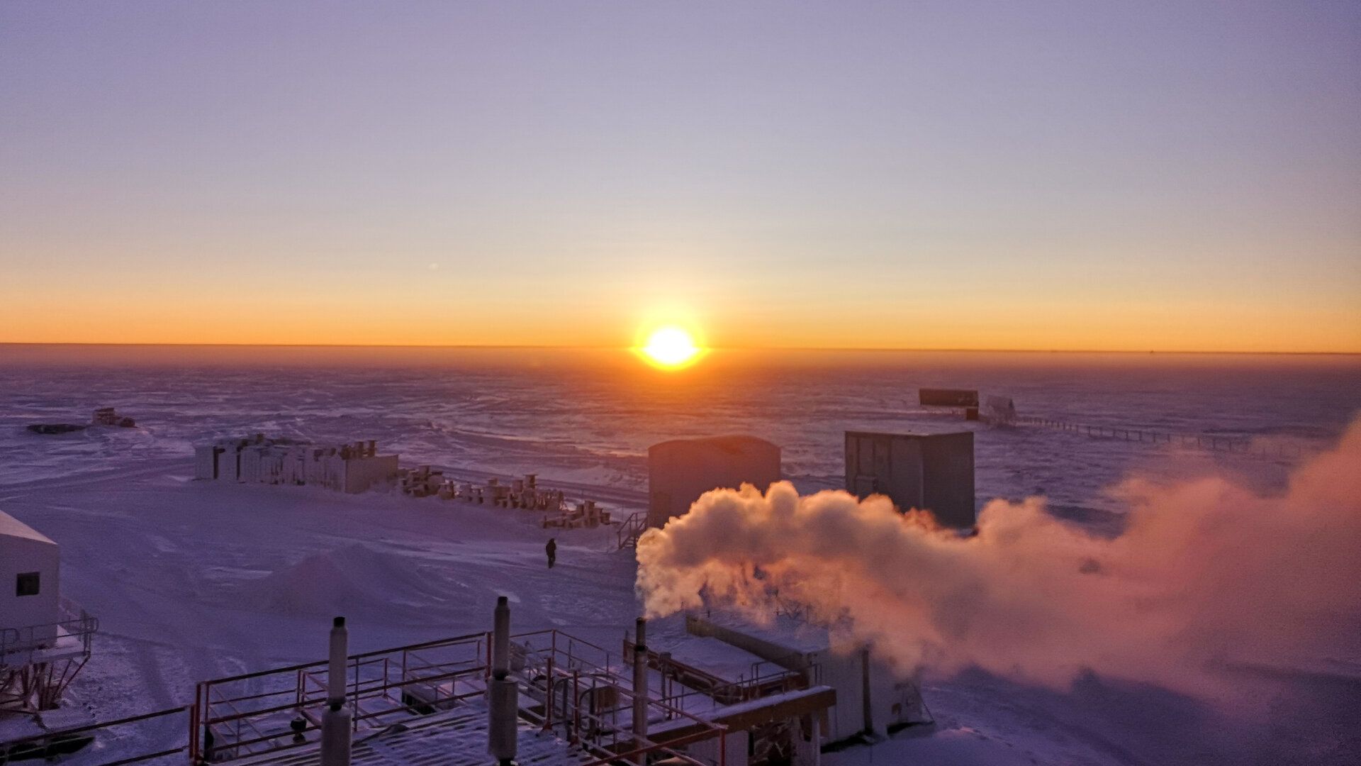 The sun is low on the horizon, shining a deep orange color.