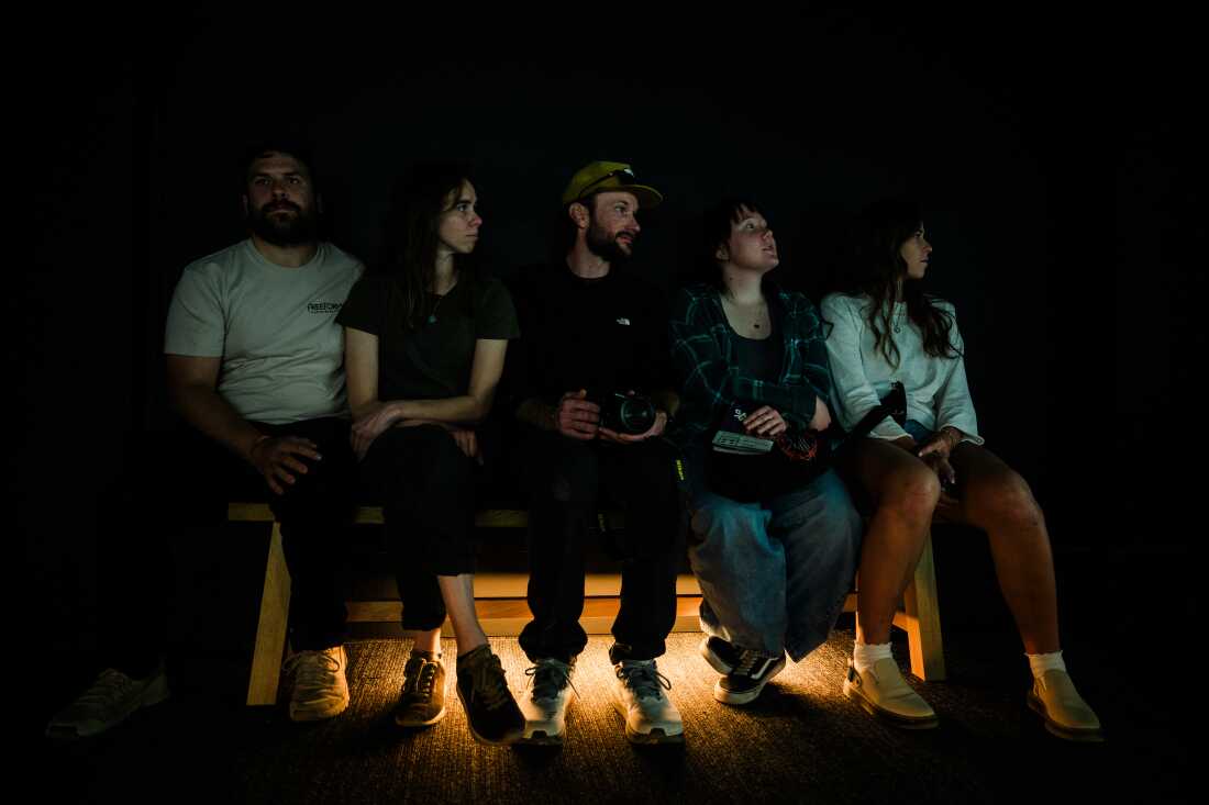 A group of friends sit in the Royal Air Force Exhibition Gallery and watch Frame Rate: Desert Pulse at the Desert Botanical Garden on April 14, 2026 in Phoenix, Arizona.