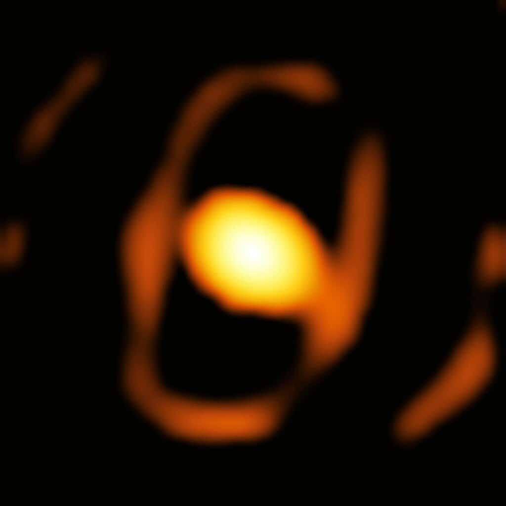 Blurry image of a star with a bright core and fiery outer layer.