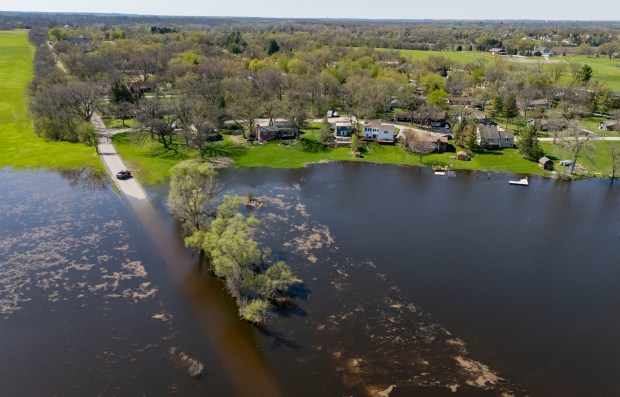 Whippoorwill Drive disappears under floodwaters as the Fox River rises in Crystal Lake on April 20, 2026. (Brian Cassella/Chicago Tribune)