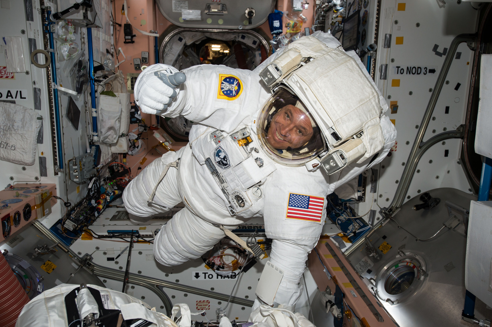 NASA astronaut Jack Fisher gives the thumbs up sign while wearing an extravehicular maneuvering unit (EMU) spacesuit prior to a spacewalk on May 12, 2017.