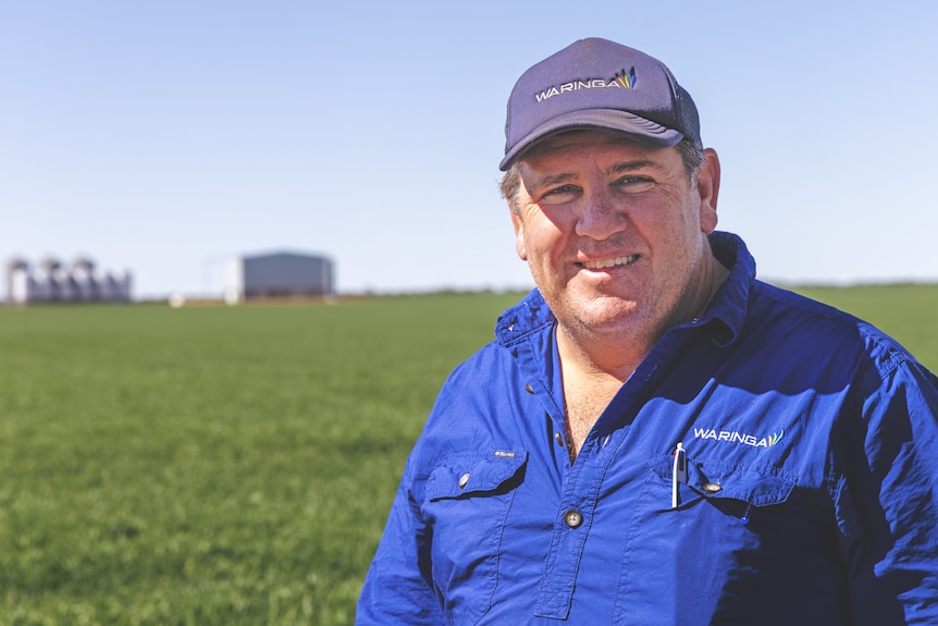 A man in blue clothes looks at the camera