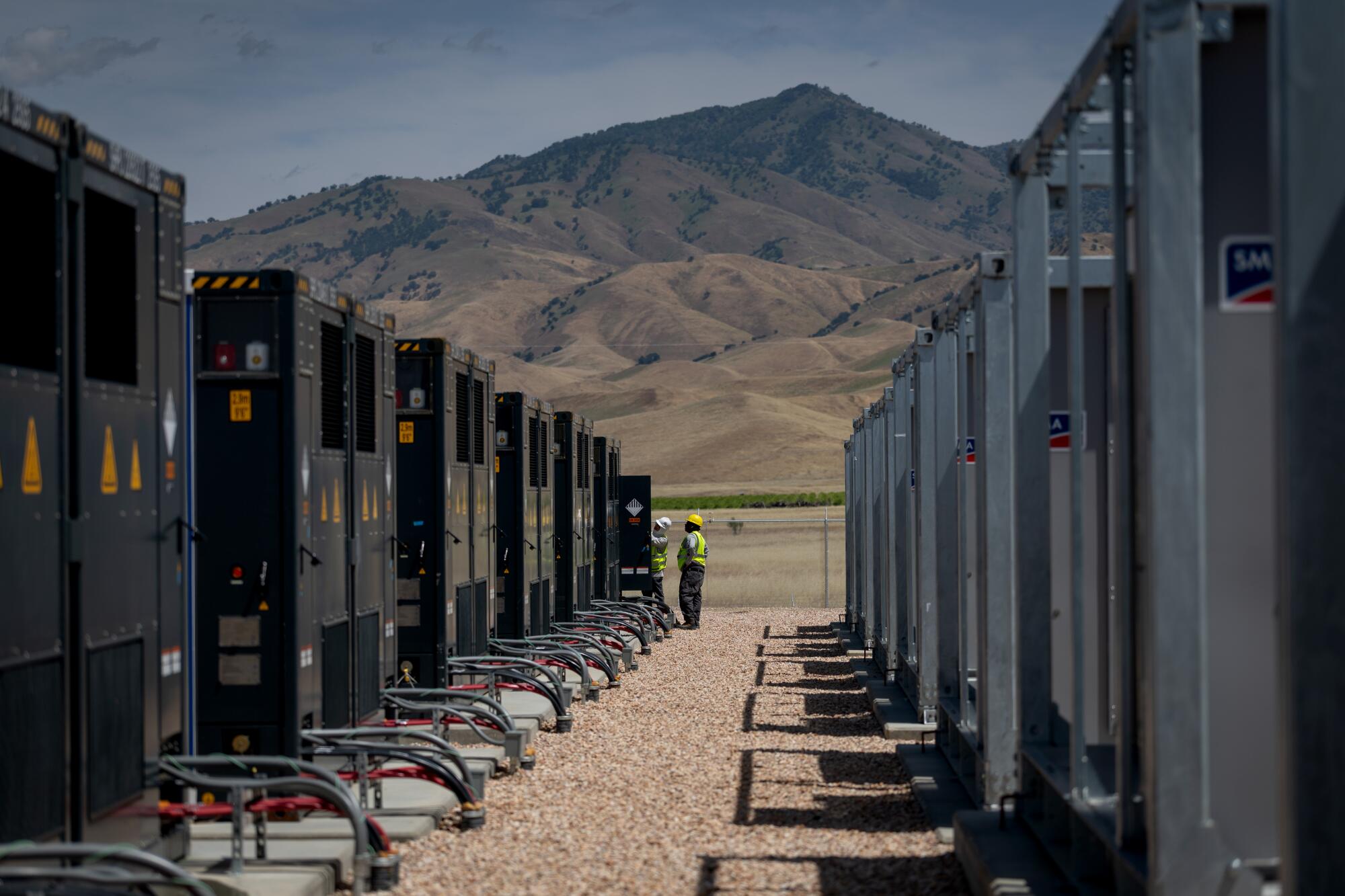 Workers inspect the battery storage system during a tour of the Pastoria facility.