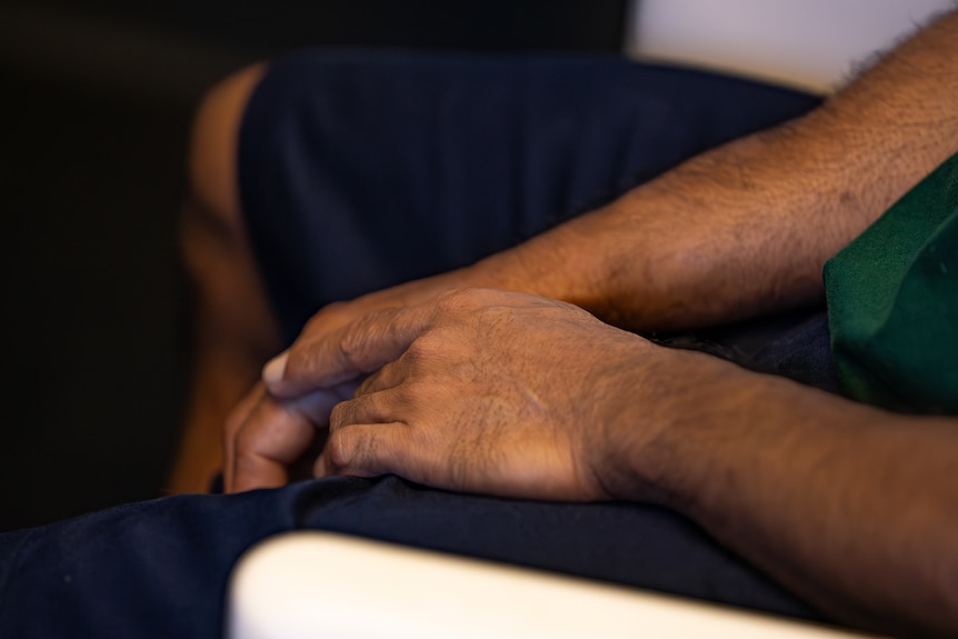 Hands of a sitting man.